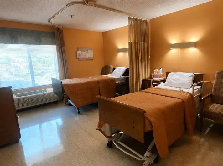 A semi-private resident room at Vivo Healthcare West Orange, beds either side of the window